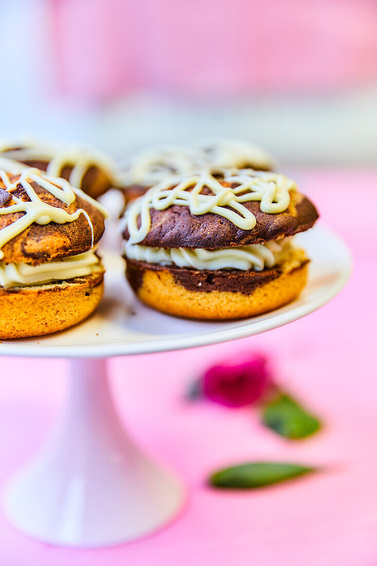 Marble donuts with cream filling on a pastry rack