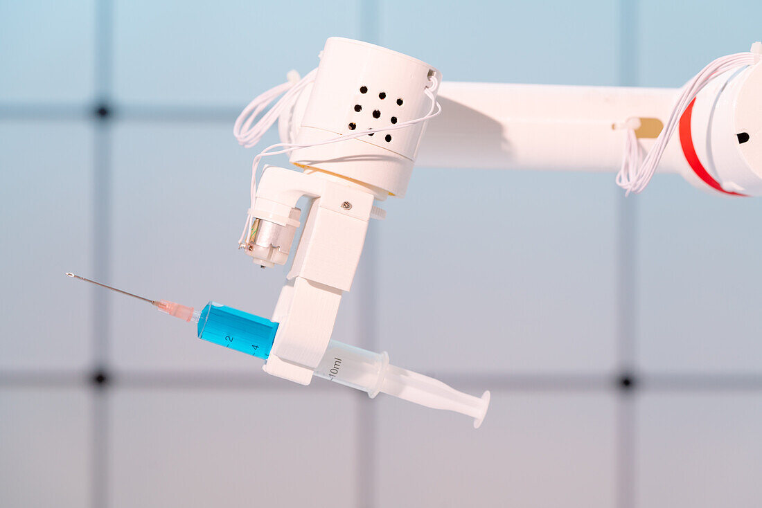 Robotic arm holding syringe