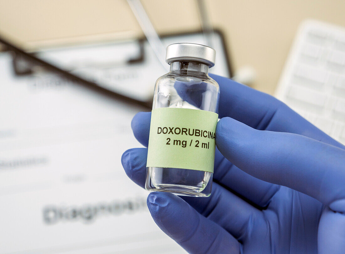 Doctor holding a vial of doxorubicin, conceptual image