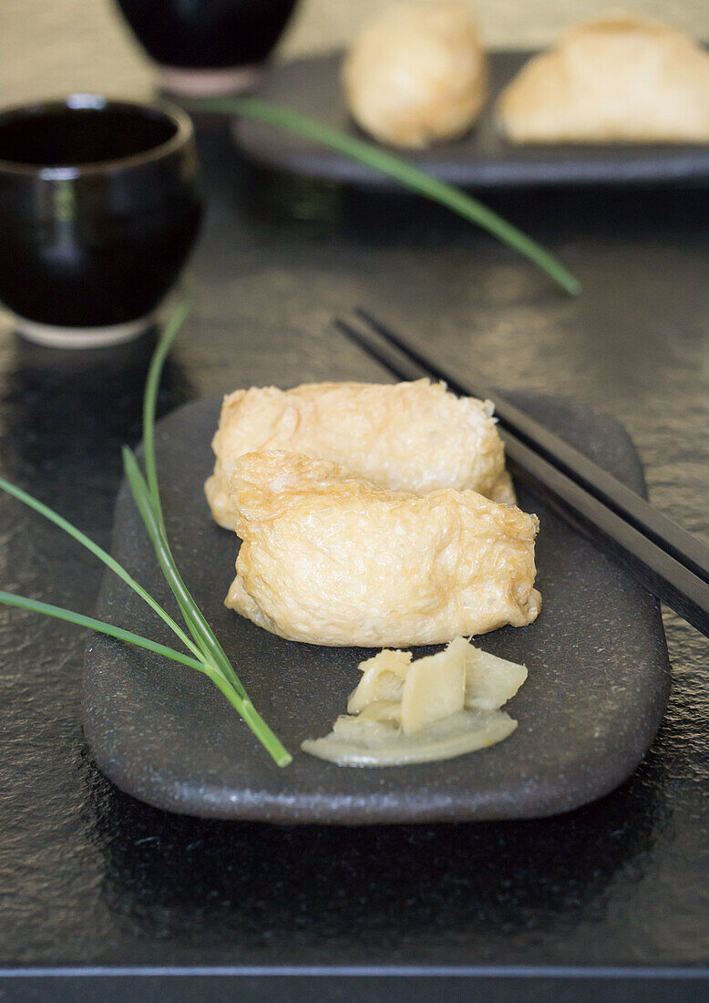 Inari Sushi (frittierte Tofu-Taschen gefüllt mit Reis) mit Gari (Ingwer)
