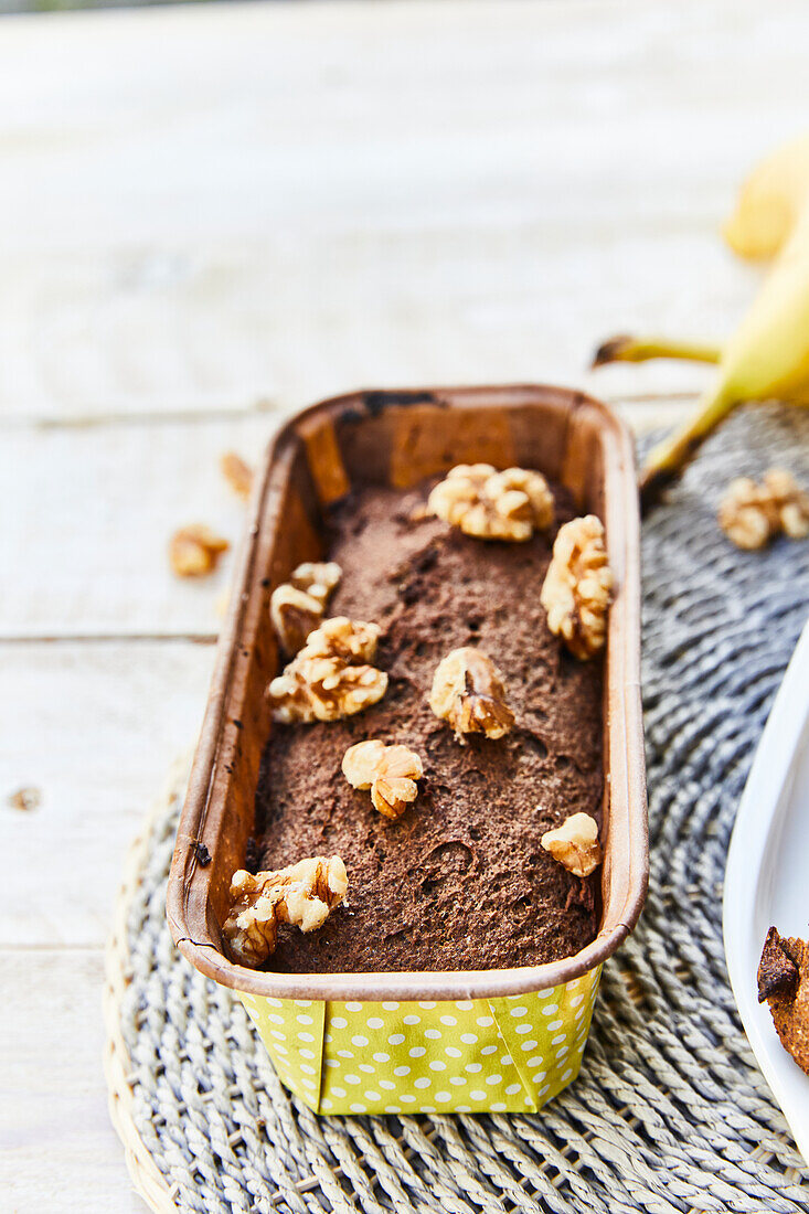 Banana bread topped with walnuts in a bread pan