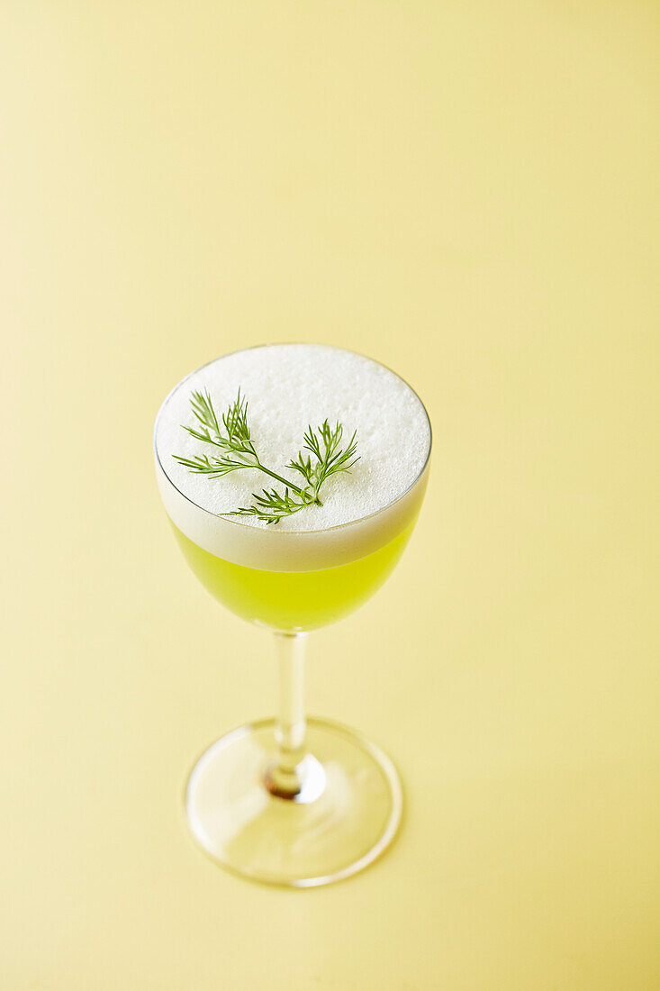 Ein grüner Cocktail, garniert mit Dill (Gin Sour)