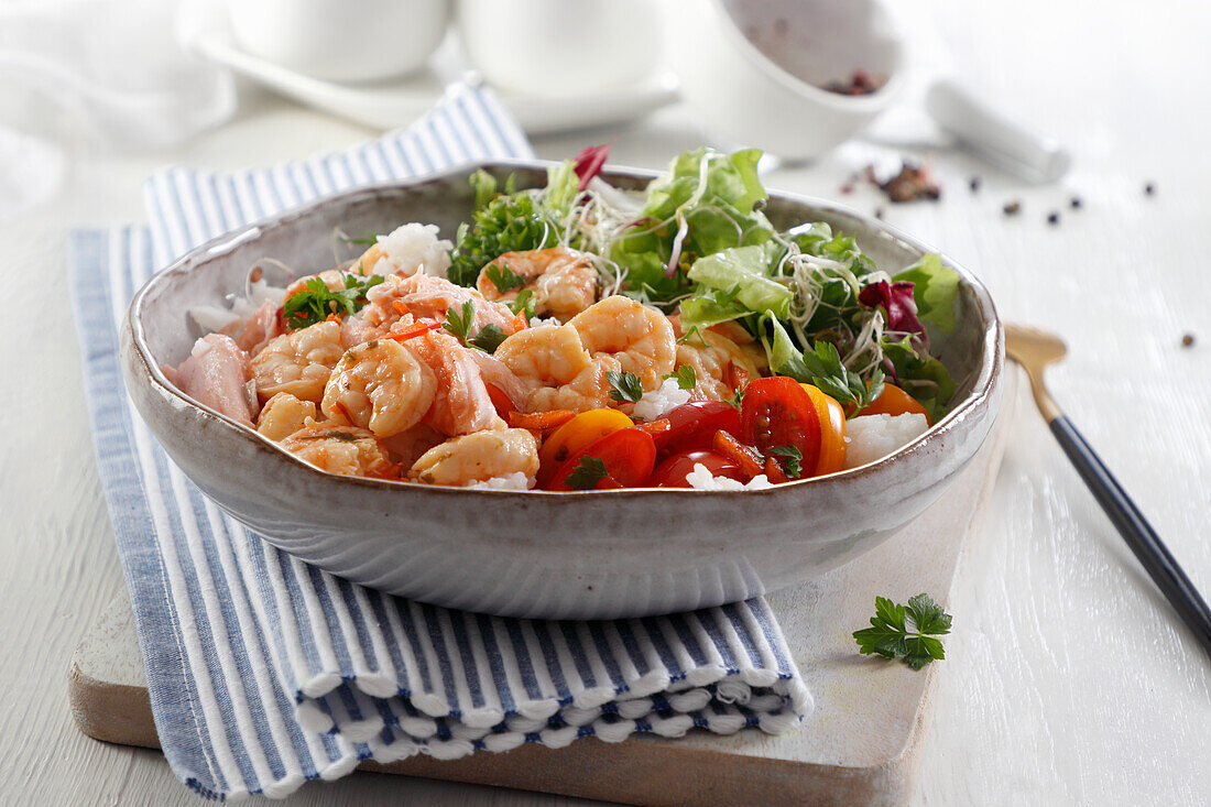 Shrimp and salmon over rice with salad