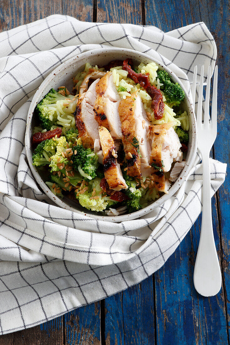 Slices of baked chicken with broccoli and rice