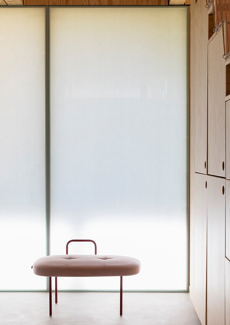 Leather stool in front of insulating glass wall and built in elements