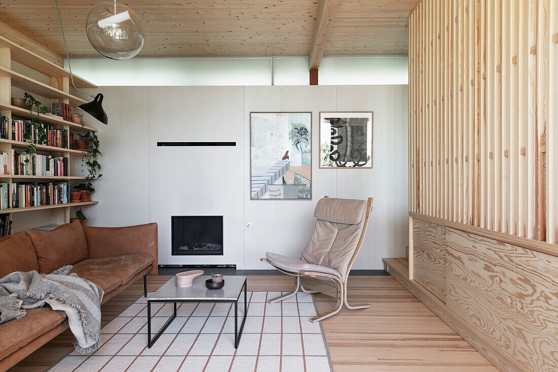 Modernes Wohnzimmer mit hellen Holzelementen, Kamin und Leder-Sitzmöbeln
