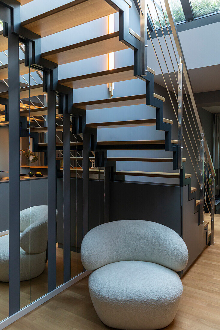 Light-colored armchair under the stairs