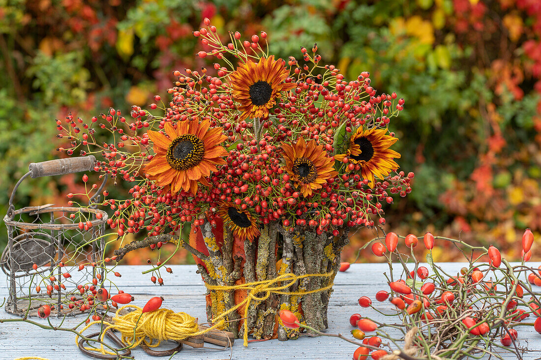 Autumn bouquet of sunflowers and rose hip twigs