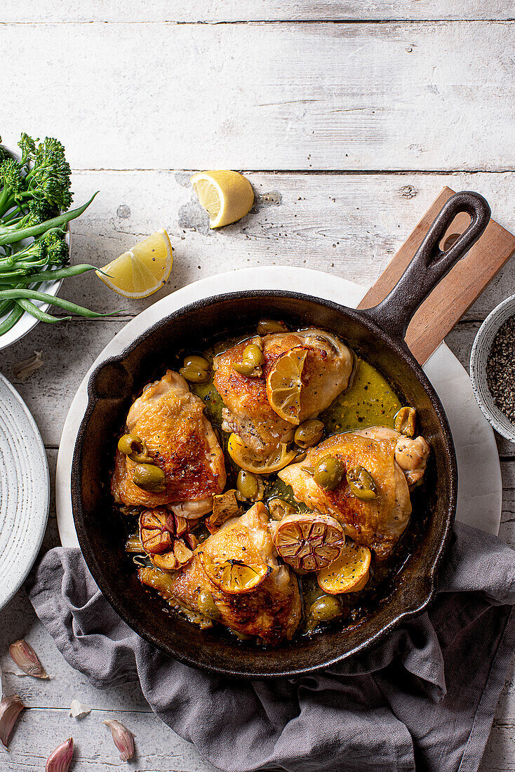 Gebratenen Hähnchenschenkel mit Knoblauch, grünen Oliven und Zitrone