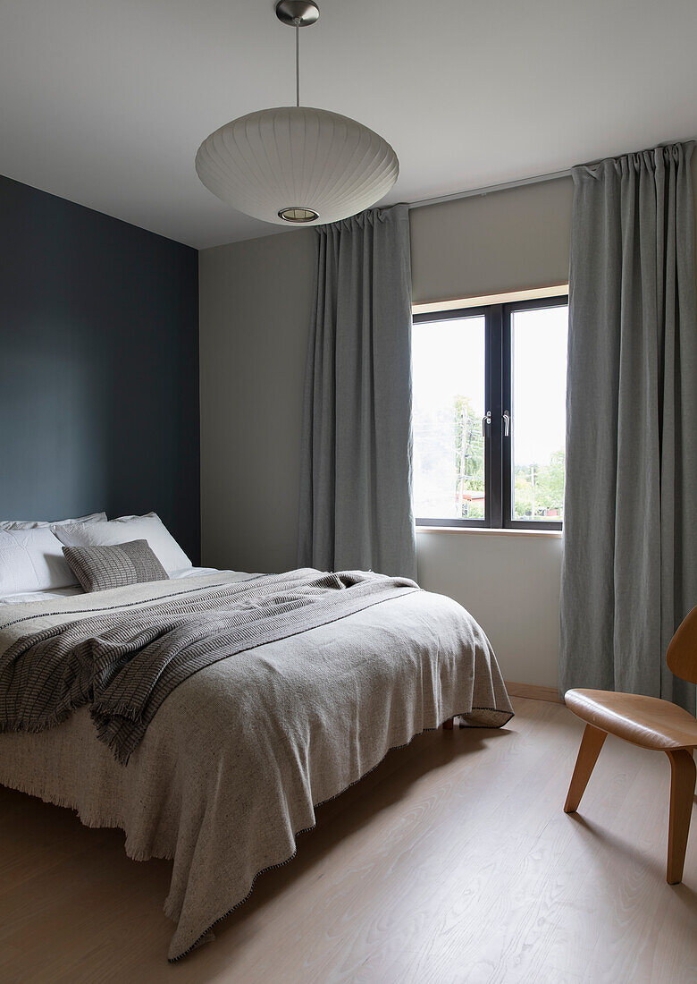 Doppelbett im Schlafzimmer, Wände in verschiedenen Grautönen