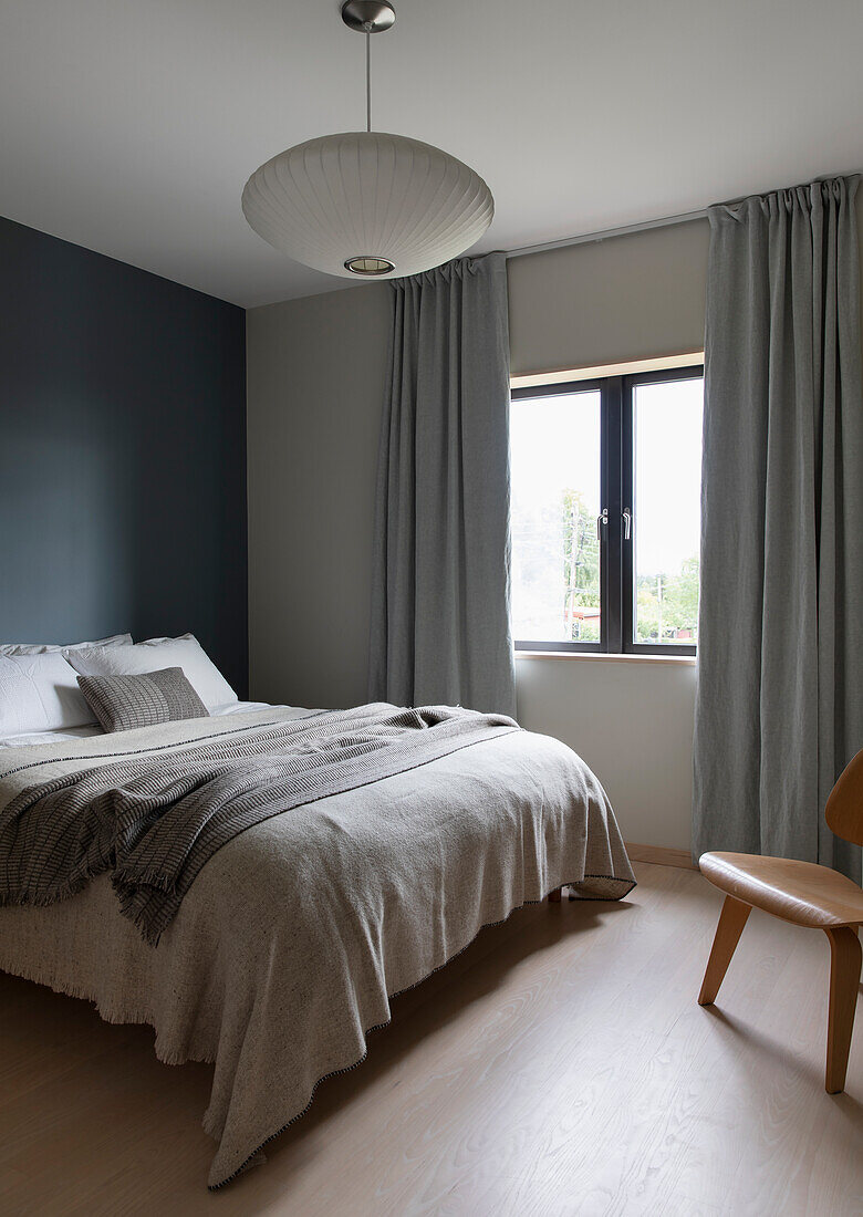 Queen bed in a bedroom, walls painted in different shades of grey