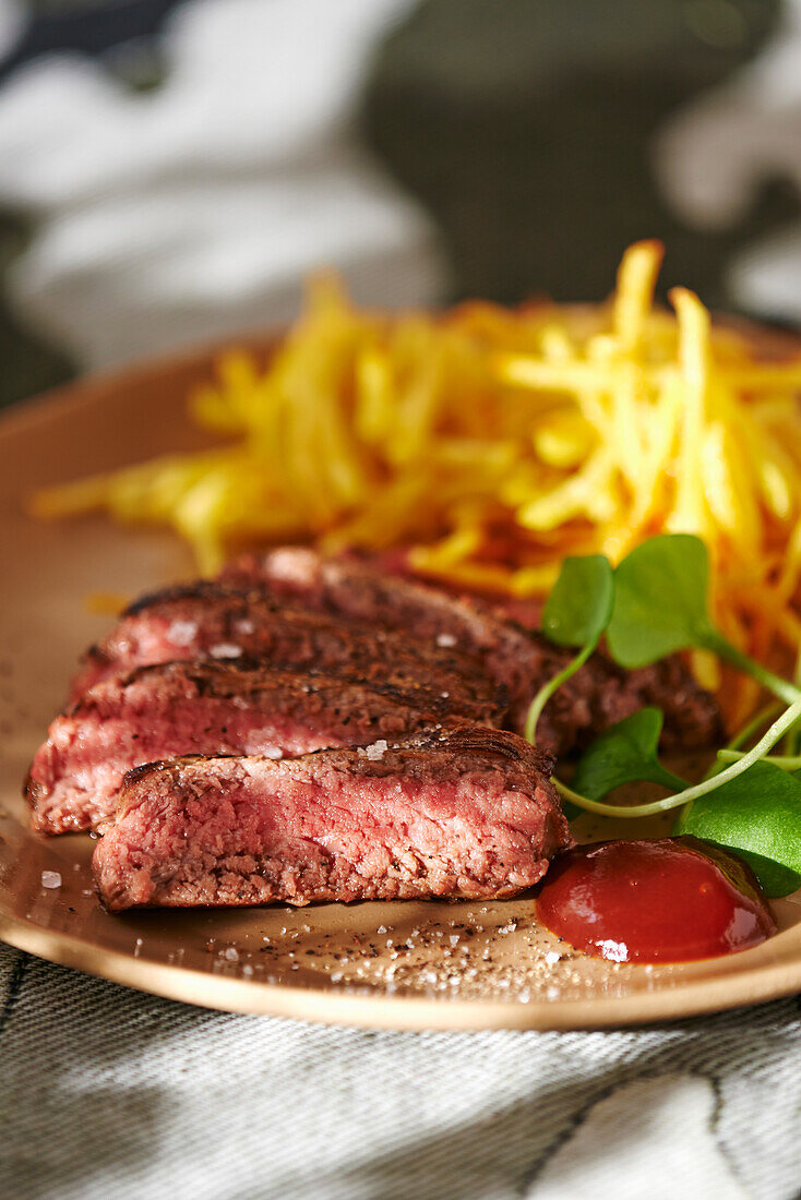 Steak with french fries and ketchup