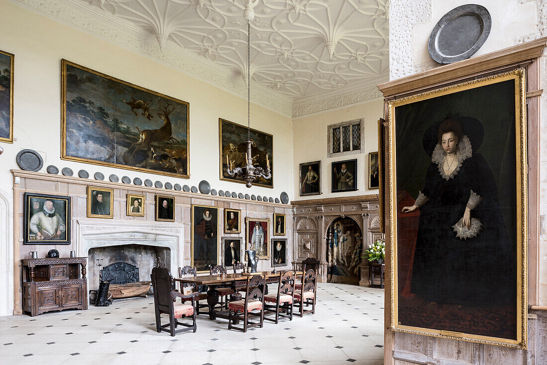 Spacious banquet hall with table, chairs and gilt-framed artworks