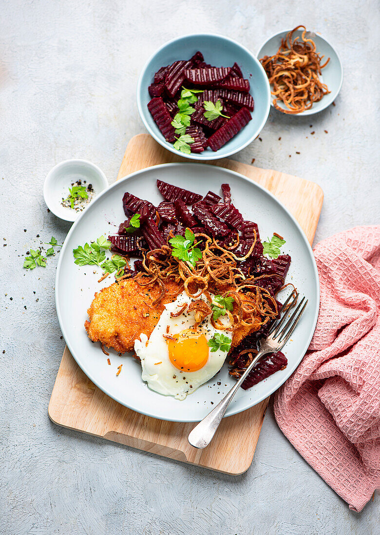 Breaded escalope with fried egg and beetroot salad