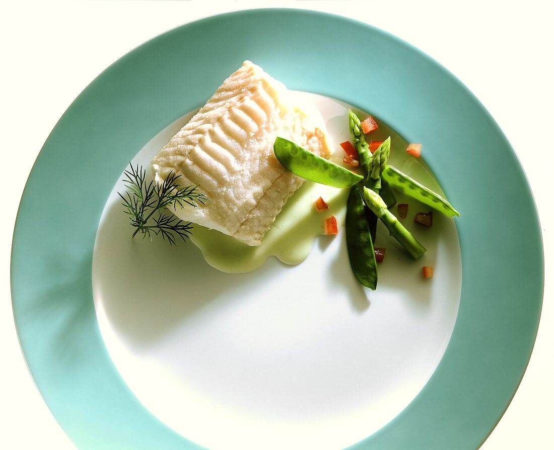 A piece of steamed redfish fillet with mangetouts and dill