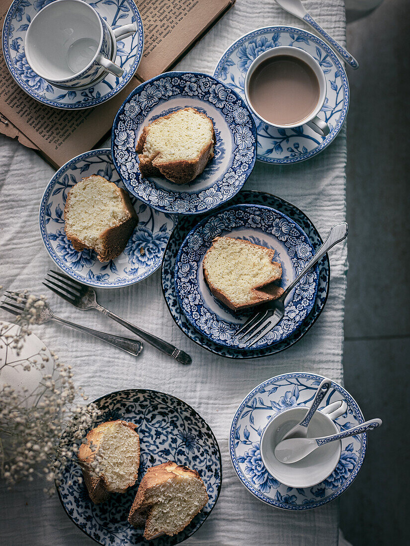 Gugelhupf slices on blue and white crockery and tea with milk