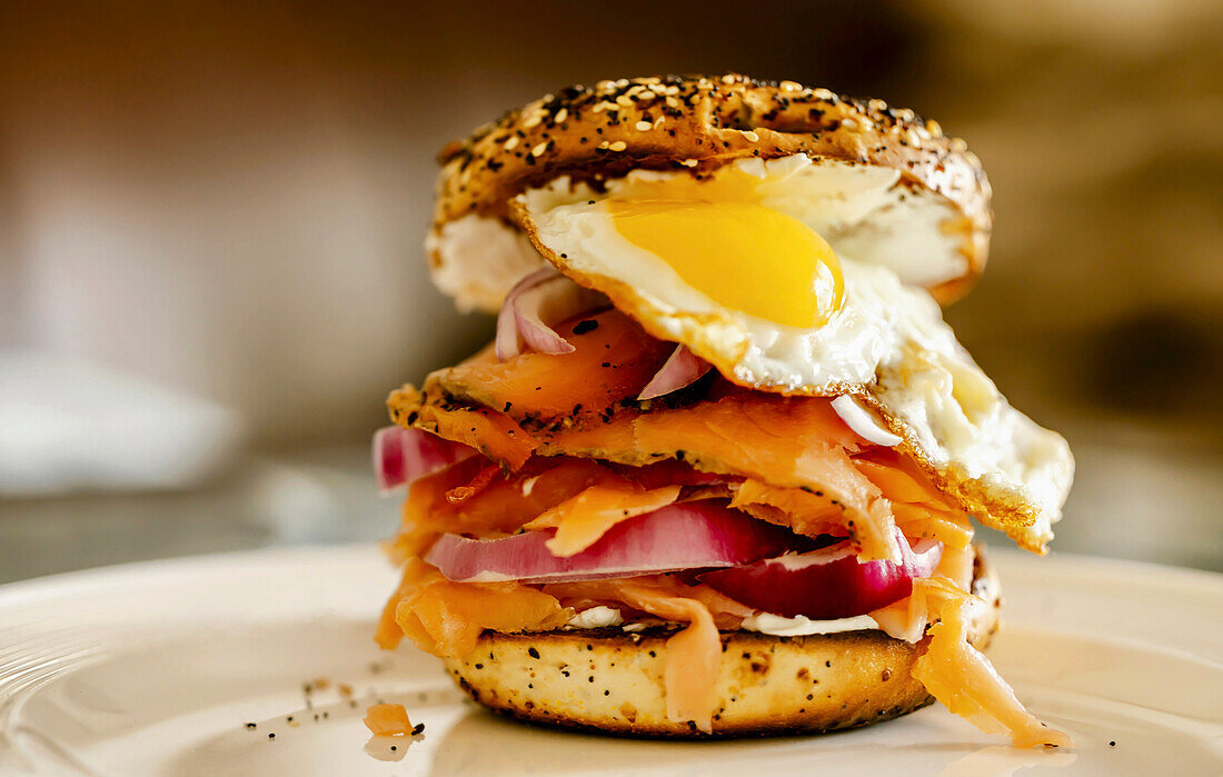 Frühstücksbagel mit Ei, Lachs und roten Zwiebeln