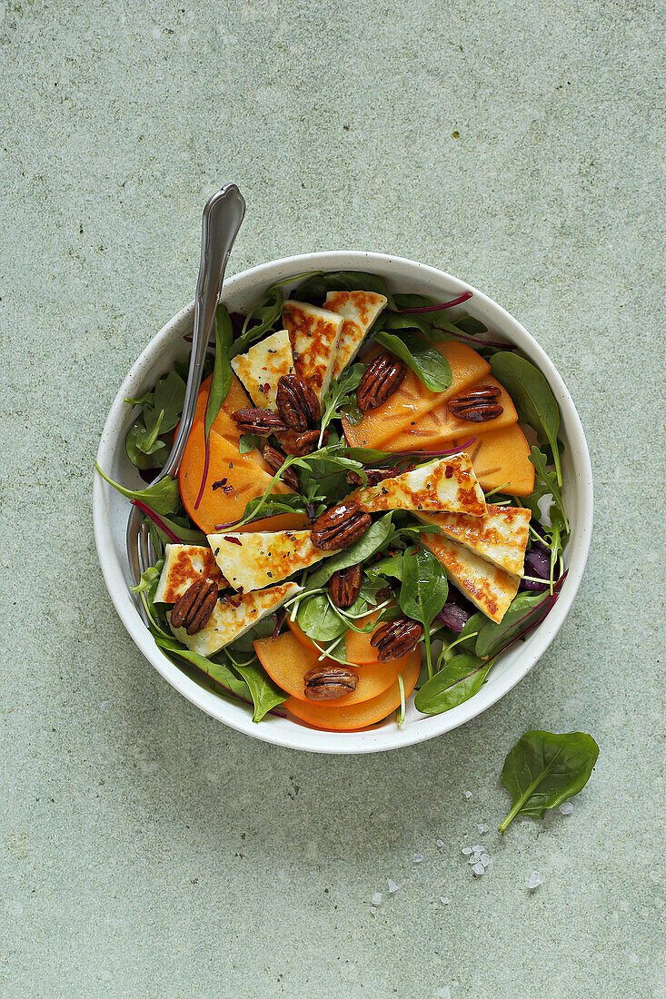 Green leaf salad with persimmon and halloumi