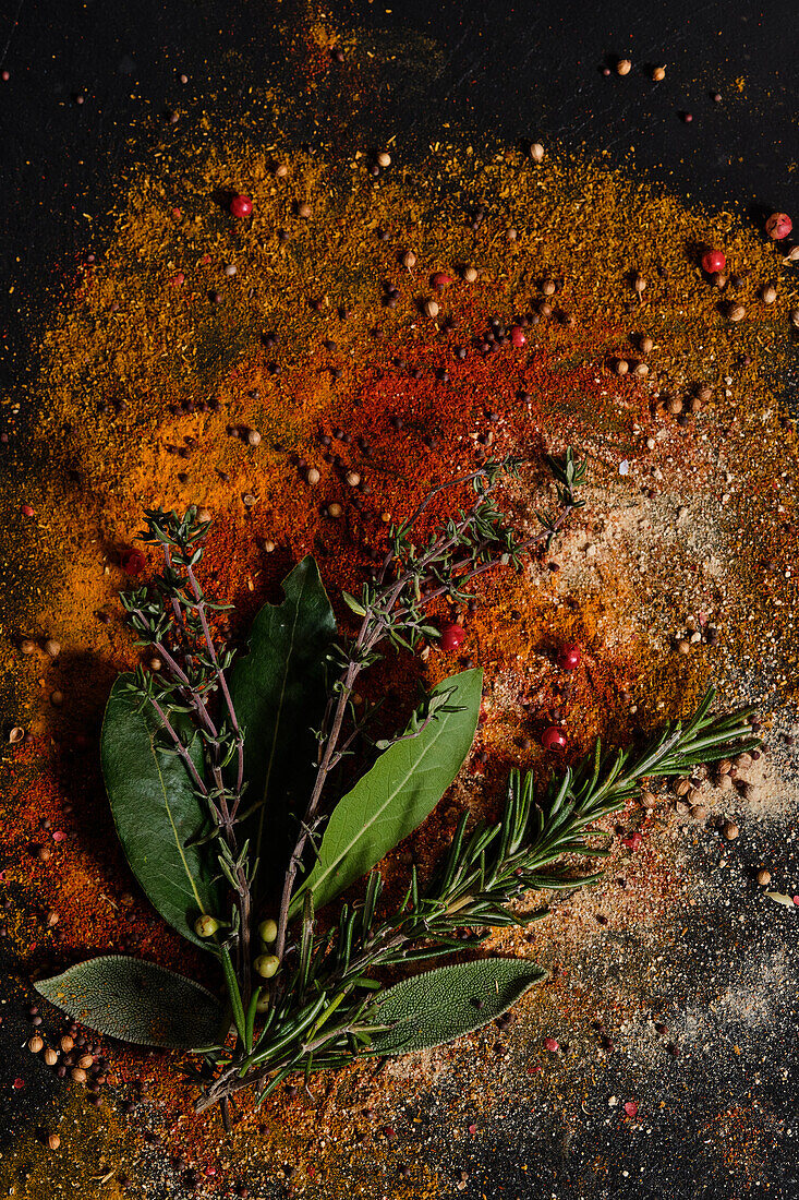 Rosemary, thyme and bay leaves on ground spices