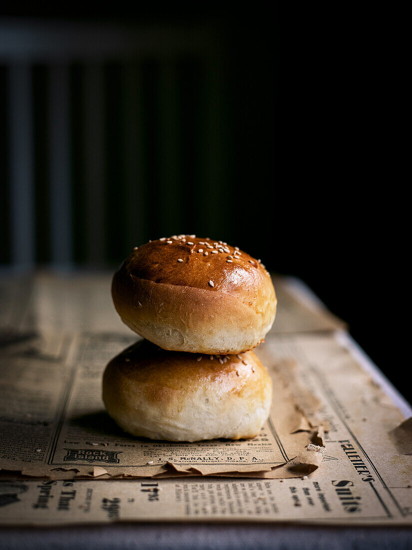 Airy rolls with sesame seeds on newspaper