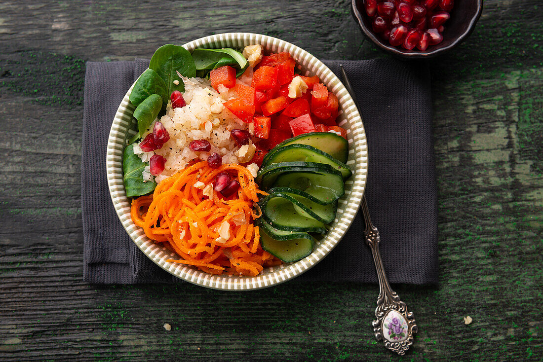 Raw vegetable salad with carrot, pepper, cucumber, white cabbage, lamb's lettuce, walnuts and pomegranate seeds