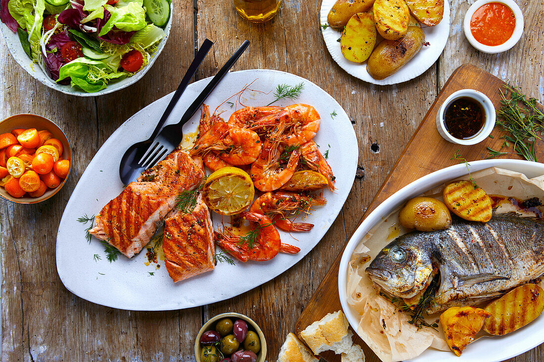 Platters of grilled fish and shrimp with side dishes