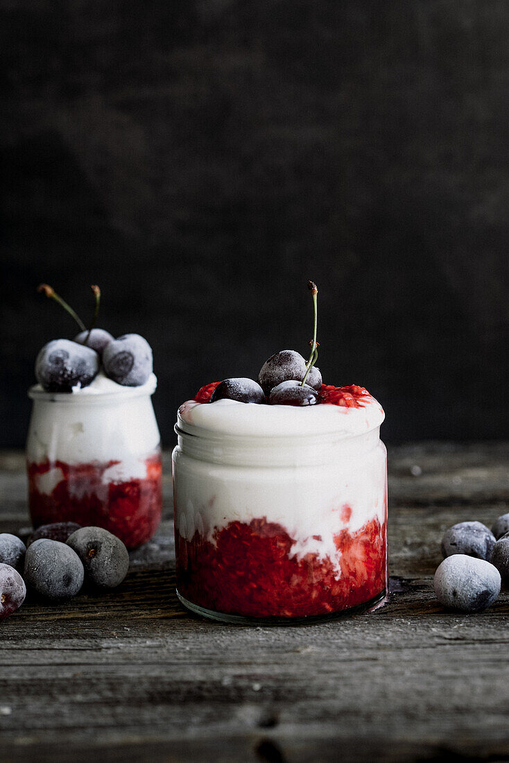 Dessert im Glas mit Himbeermousse, Joghurt und gefrorenen Kirschen