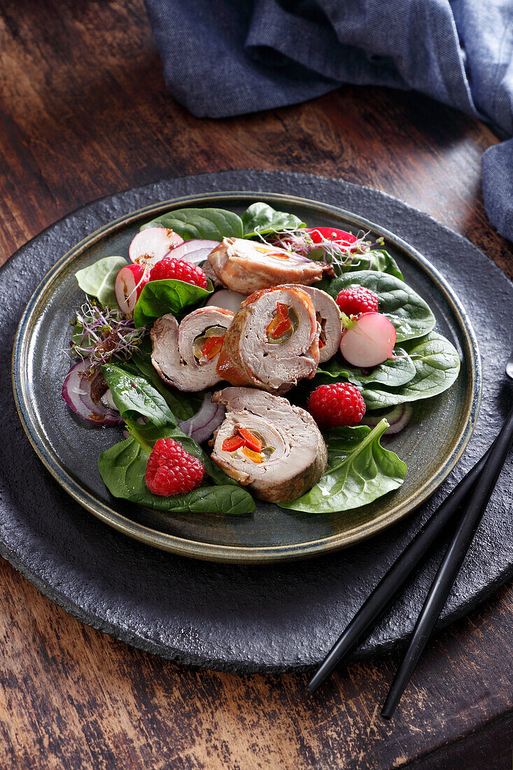 Duck breast roulade on spinach salad with raspberries