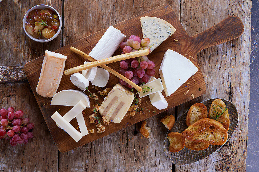 Cheese board with grapes, nuts and grissini