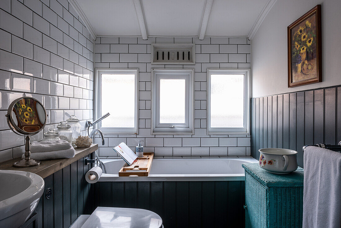 Subway tiles and wood paneling in the bathroom of a converted Victorian railway carriage house