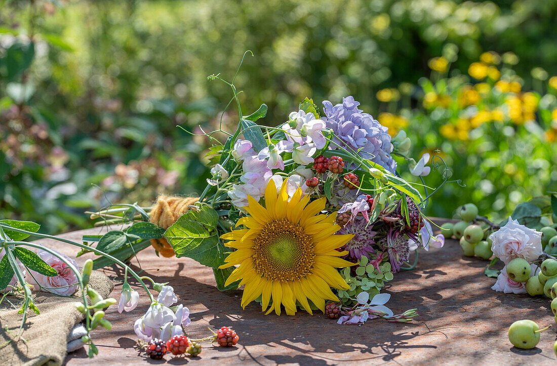 Spätsommerlicher Blumenstrauß mit Sonnenblumen, Hortensien, Duftwicken und Brombeerzweigen