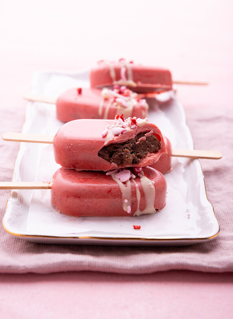Vegane Cakesicles mit rosa Reismilchschokolade überzogen