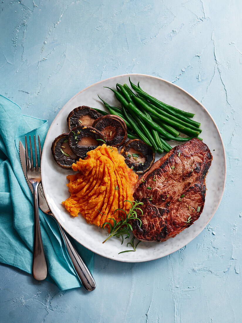Steak with mushrooms, green beans and mashed sweet potatoes