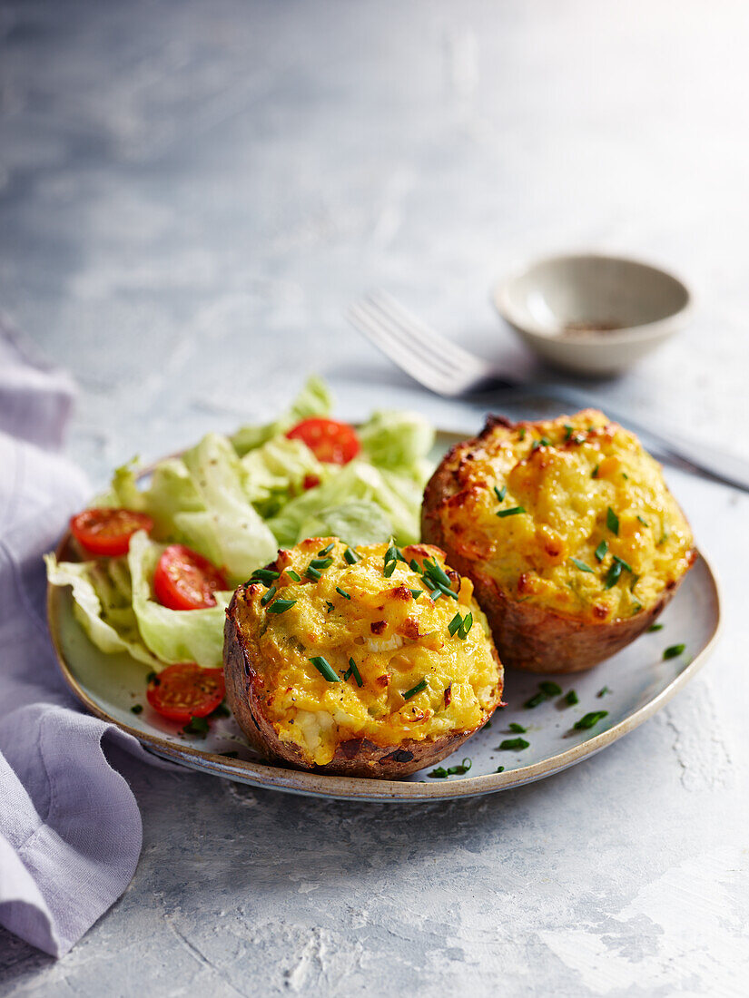 Stuffed potato skins with creamy corn filling and a side salad