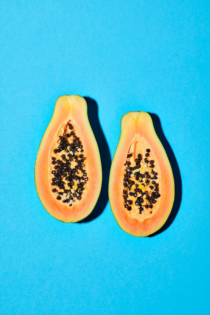 Halbierte Papaya auf blauem Untergrund