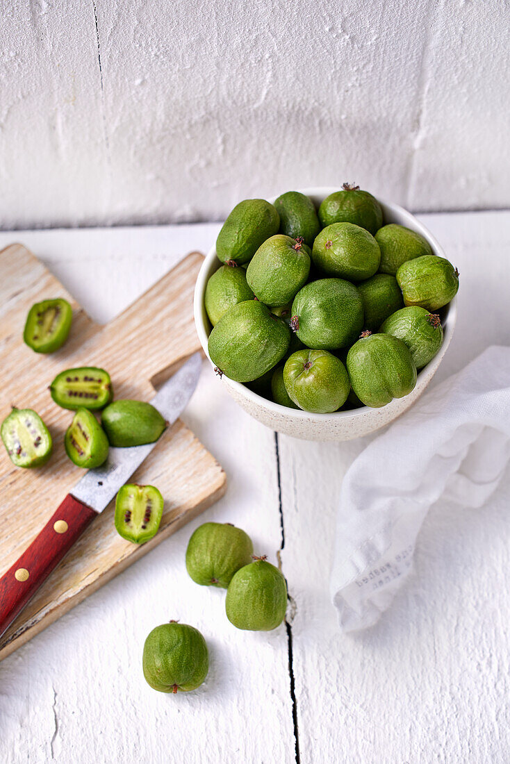 Kiwi berries in a bowl and on a wooden board