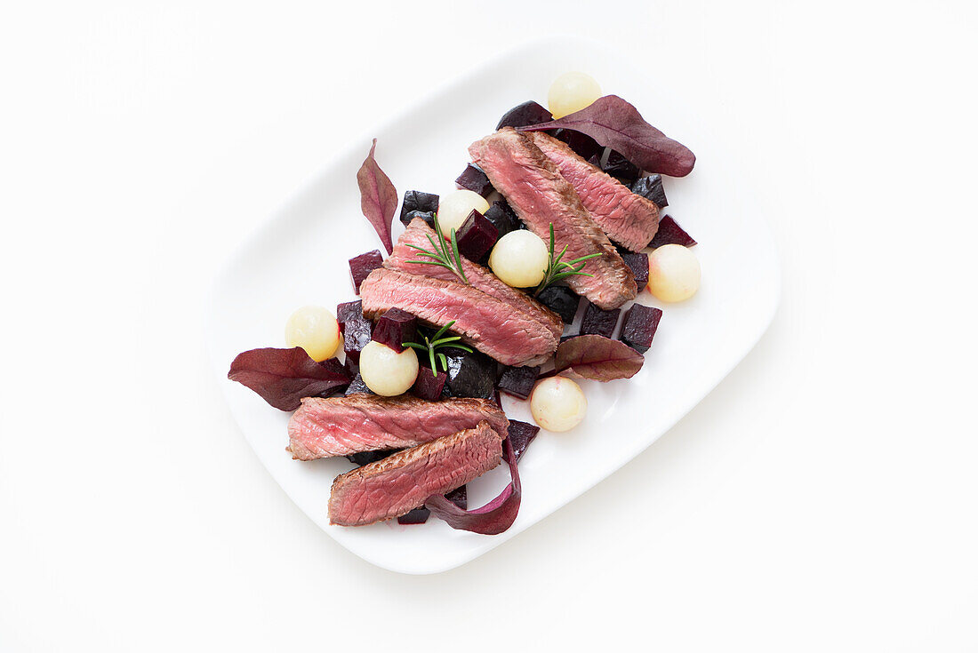 Sirloin steak slices with diced beets and potato balls
