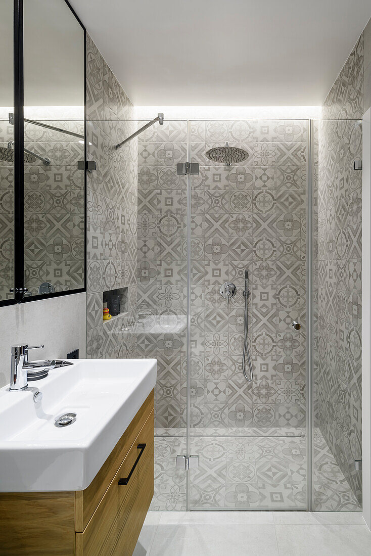 Bathroom vanity and shower area in the bathroom in grey tones with stoneware tiles