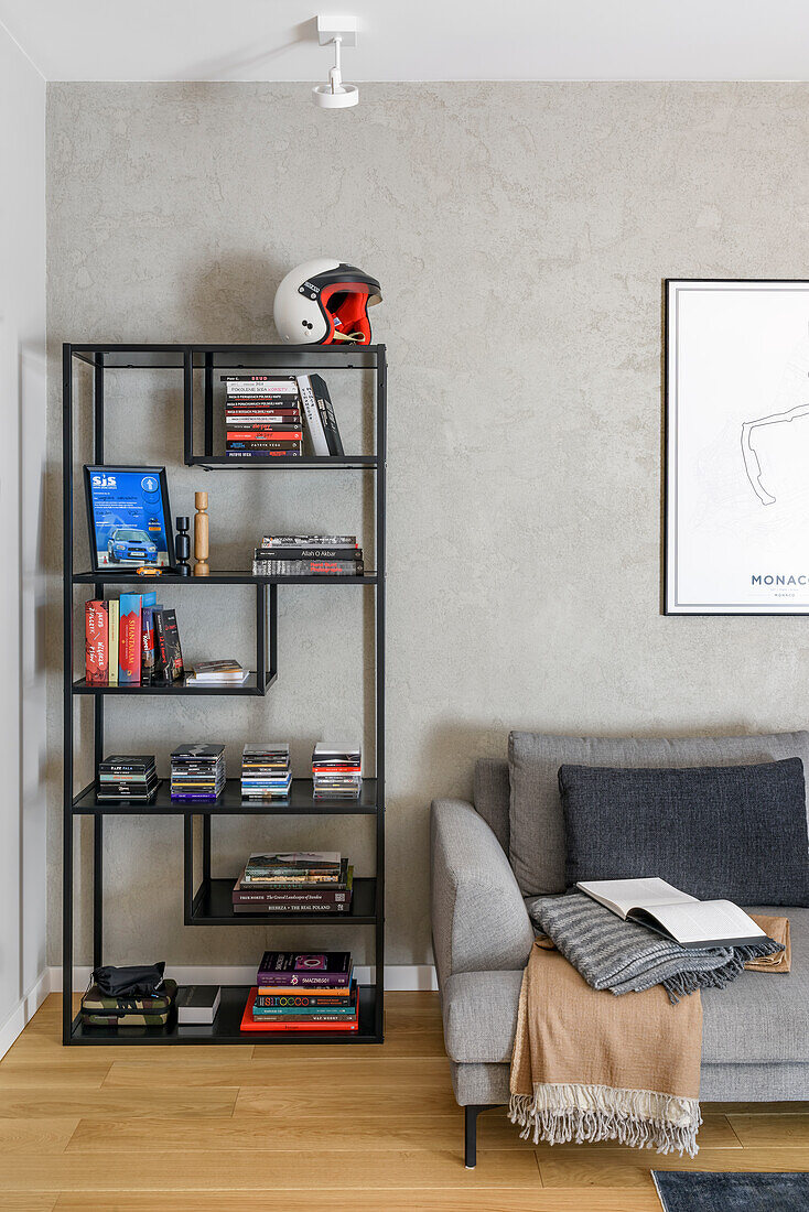 Open shelf next to sofa in a masculine single bedroom flat