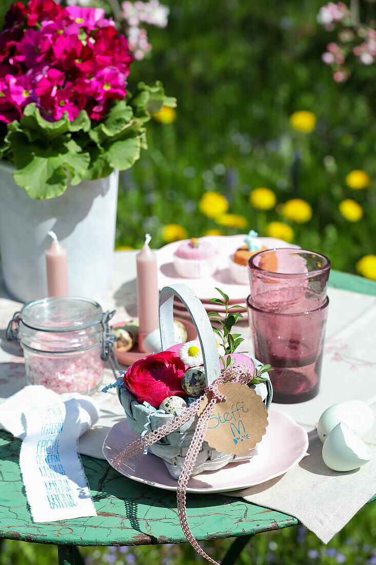 Körbchen mit Blüten und Eiern gefüllt, als Platzanweiser, an gedecktem Ostertisch