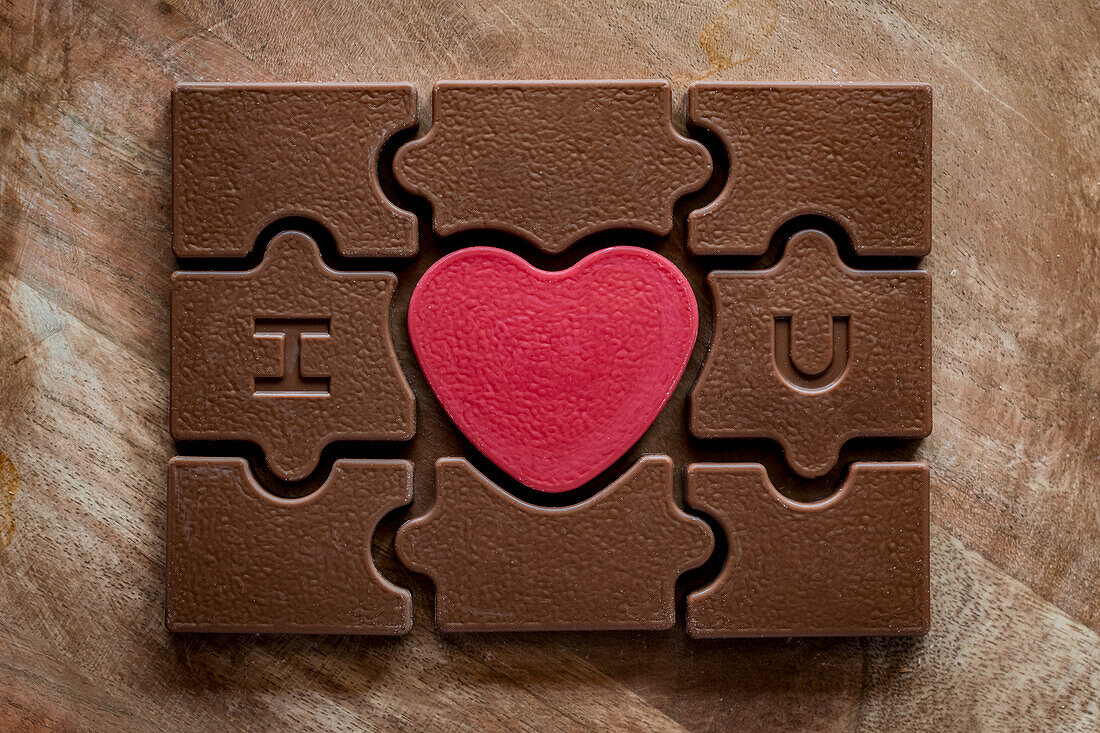 Schokoladen-Puzzle zum Valentinstag mit rotem Herz in der Mitte