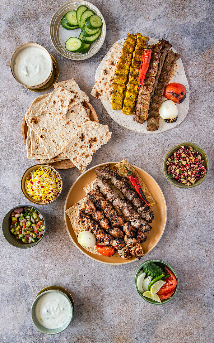 Kabab Koobideh (Iranian barbecue skewers) with salads, rice and tandoor bread