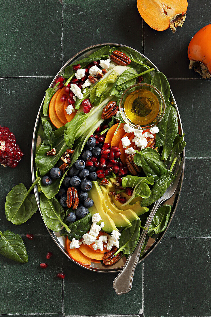 Spinach salad with persimmon, blueberries, pomegranate, goat cheese, and caramelized pecans