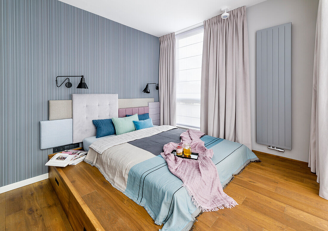 Double bed with headboard made of several upholstered elements on wooden platform