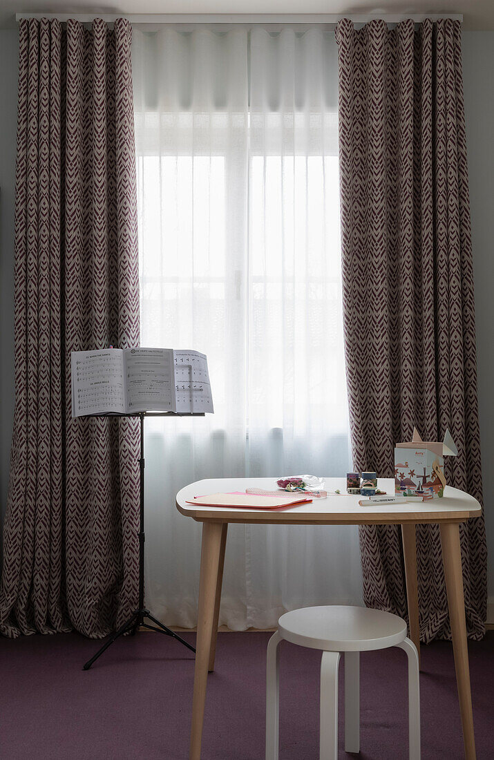 Table with stool and music stand in front of window