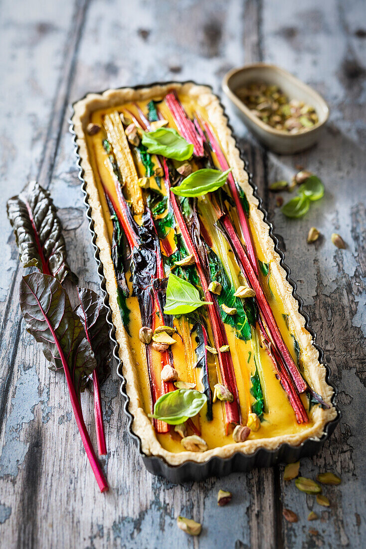 Vegetarische Quiche mit buntem Mangold, Creme fraîche und Pistazien