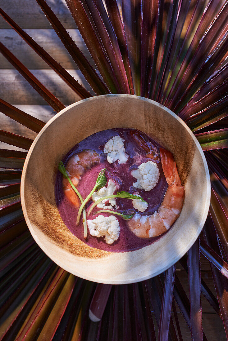 Purple sweet potato soup with cauliflower florets and shrimp
