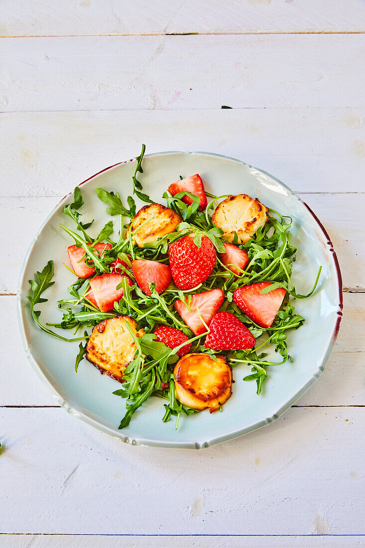 Arugula salad with strawberries and baked goat cheese