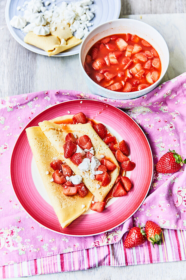 Crepes with strawberries and meringue served with cold strawberry bowl