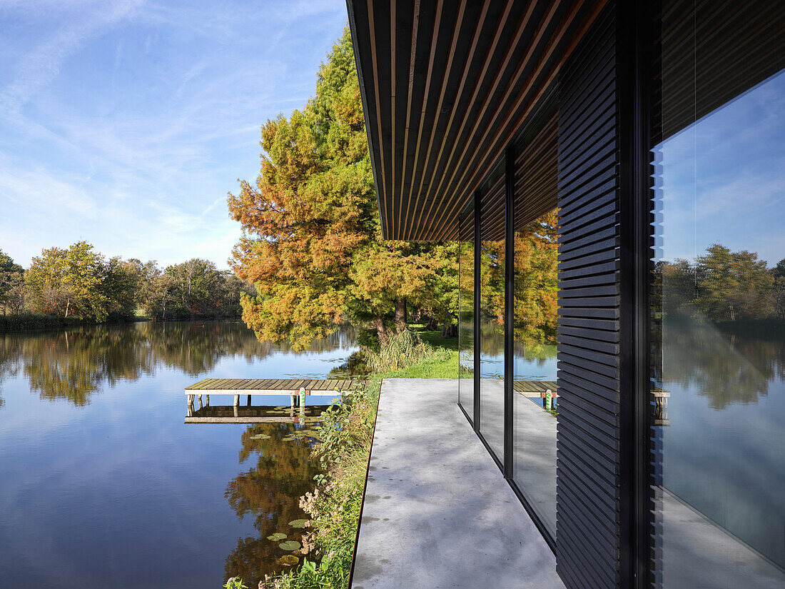 Haus mit Glas- und Holzfassade am See